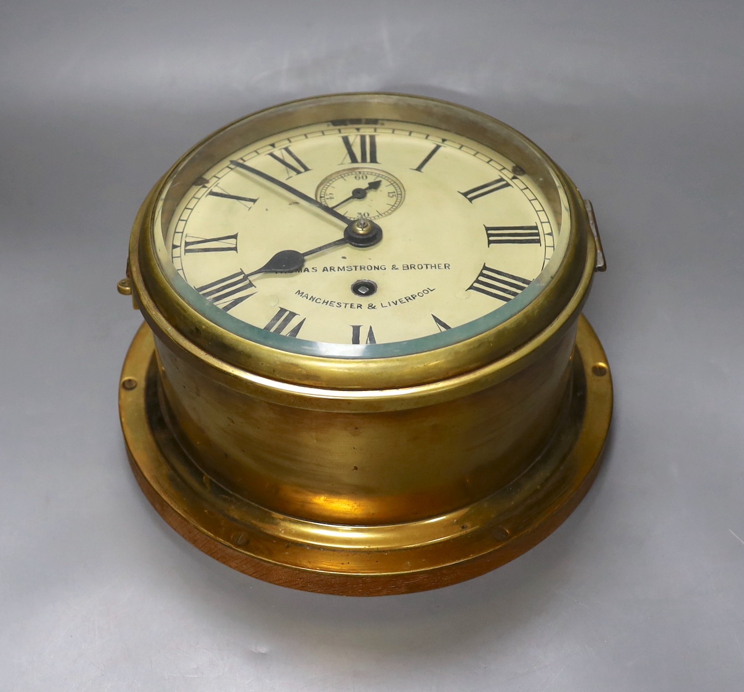 A brass ship’s bulkhead timepiece with key